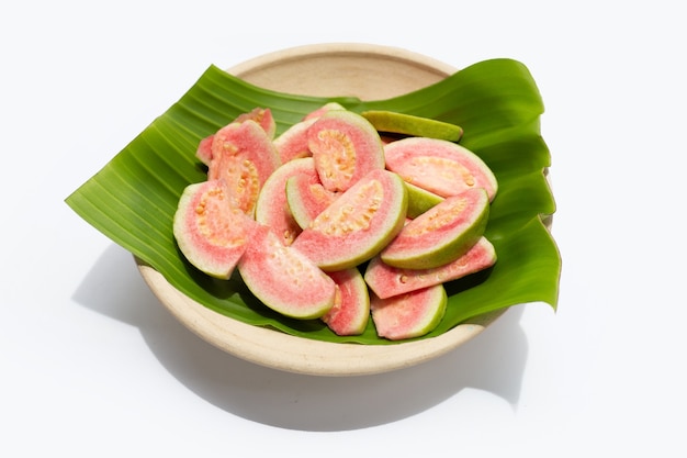 Fresh pink guava on banana leaf in plate on white background.