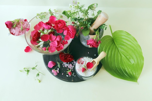 Свежие розовые и фиолетовые розы, вода и морская соль с лепестками цветов