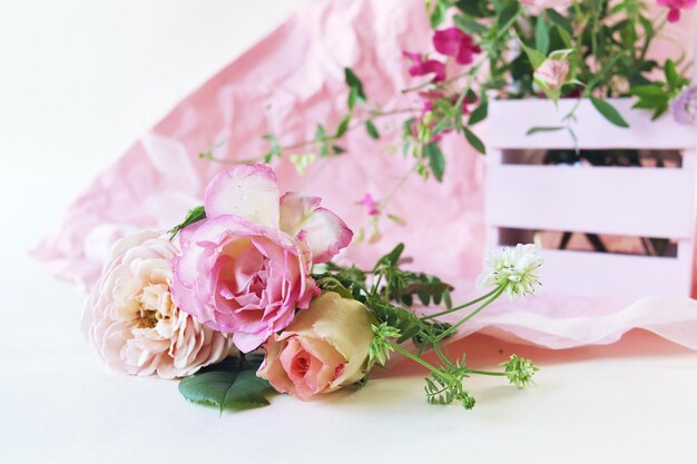 낭만적인 인사의 개념에 밝은 배경에 바구니 꽃에 신선한 핑크 장미