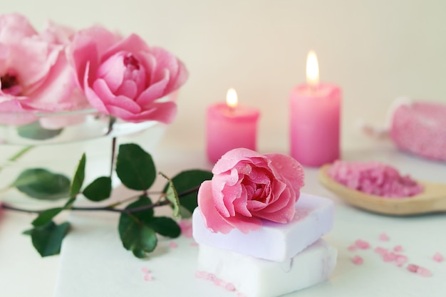 Fresh pink roses, water, petals, candles, body care products