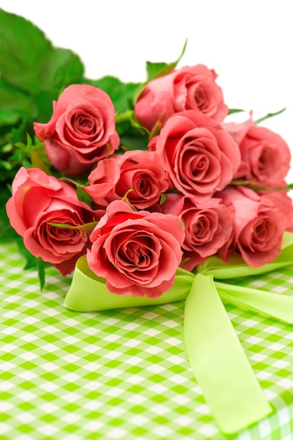 Fresh pink roses with gift over white background