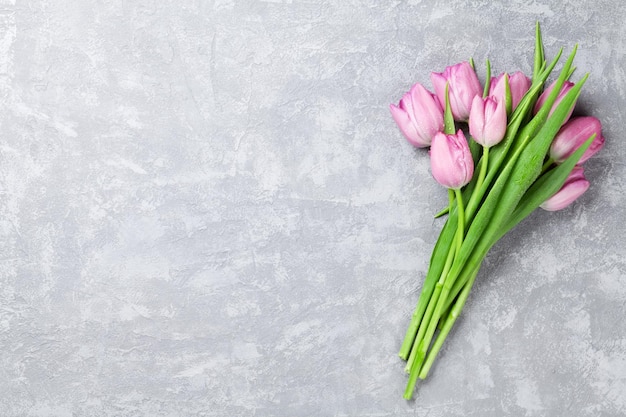 Fiori di tulipano rosa freschi sul tavolo di pietra