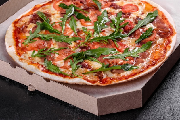 Fresh pizza baked in oven with arugula, salami, cherry tomatoes and mozzarella. Italian cuisine