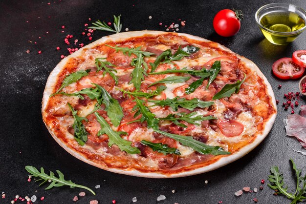 Fresh pizza baked in oven with arugula, salami, cherry tomatoes and mozzarella. Italian cuisine