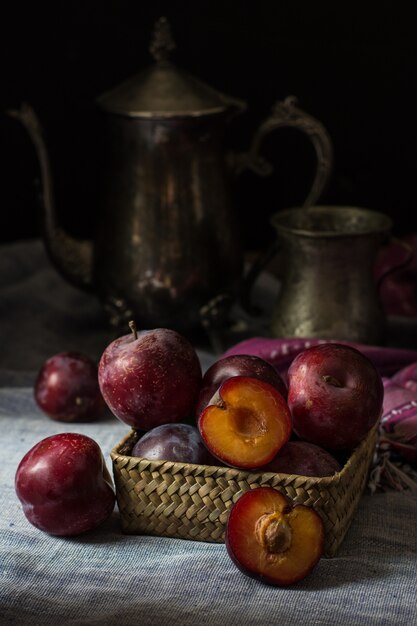 Fresh plum. Autumn harvest. Red plums. Yellow plum. napkin and vintage kettle and glass.