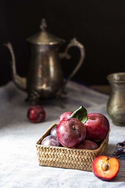 Fresh plum. Autumn harvest. Red plums. Yellow plum. napkin and vintage kettle and glass. 