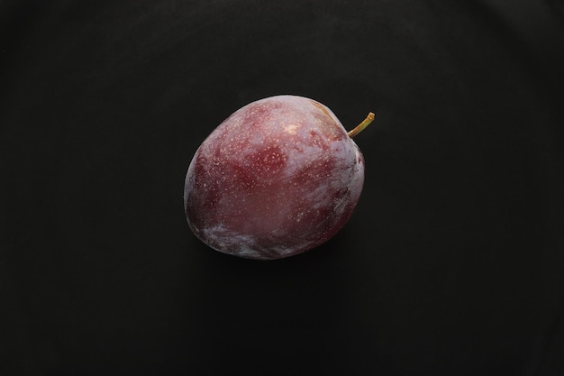 Fresh plums in a black plate