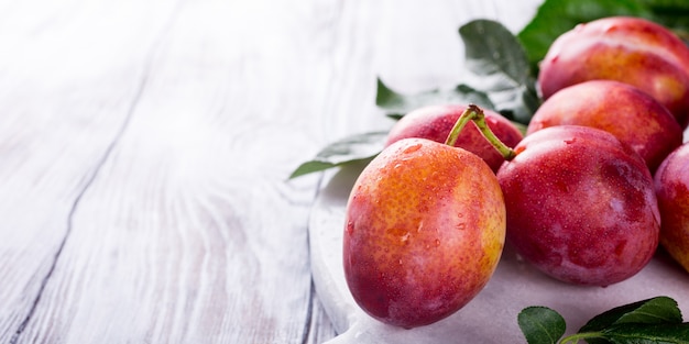 Fresh plums on marble cutting board