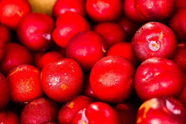 Fresh plums in a pile at the local farmer's  market.