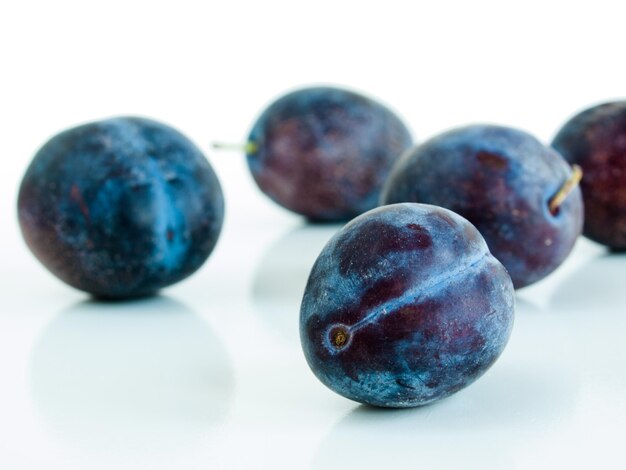 Fresh plums on white background.