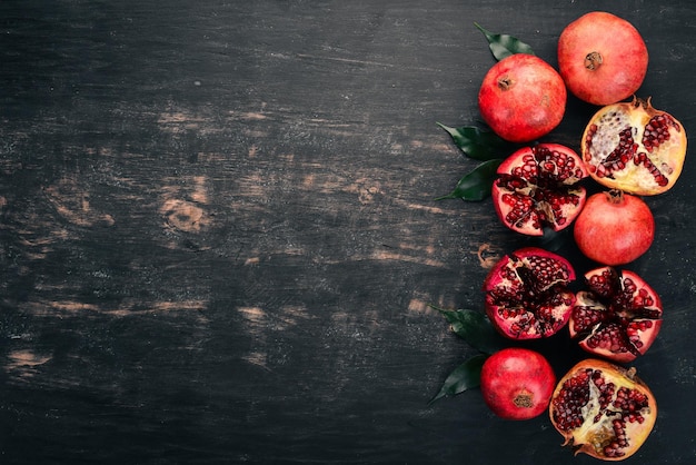 Fresh pomegranate On a black wooden background Top view Copy space