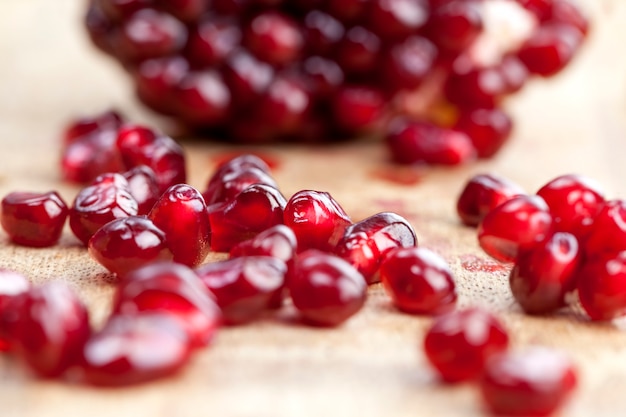 Fresh pomegranate close-up, red and ripe fruit pomegranate with red grains, delicious and healthy pomegranate divided into several parts with red seeds