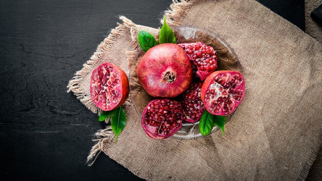 Fresh pomegranate on a dark Wooden surface Top view