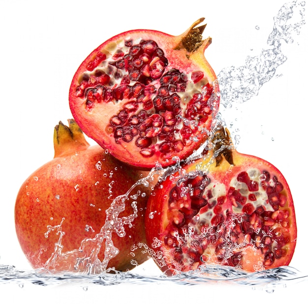 Fresh pomegranate falling in water