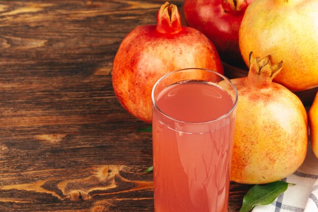 Fresh pomegranate juice on wooden table close up