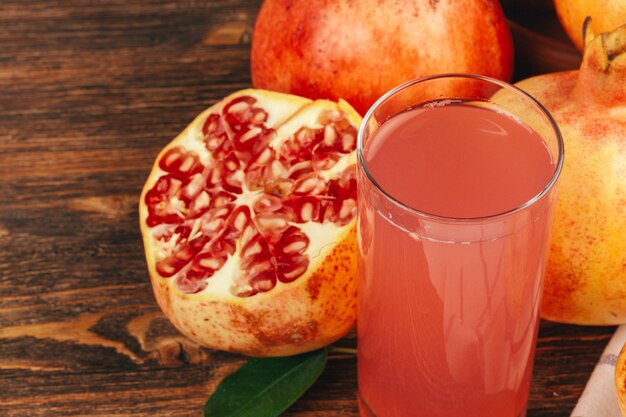 Fresh pomegranate juice on wooden table close up