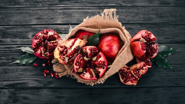 Fresh pomegranate in an old bag On a wooden background Top view Copy space