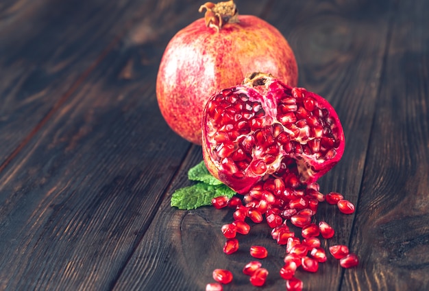 Photo fresh pomegranate on the wooden table: cross section