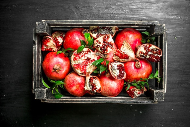 Fresh pomegranates in a box on the black chalkboard