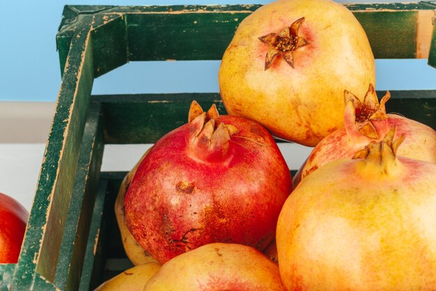 Fresh pomegranates in an old box  on wooden surface