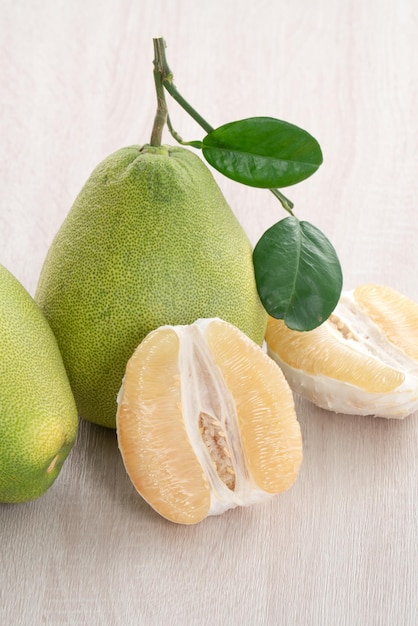 Fresh pomelo fruit on wooden table background