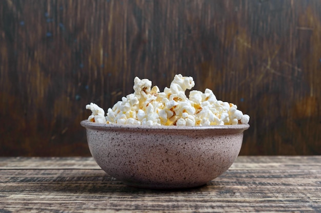 Fresh popcorn in a bowl on a wooden background Rustic style