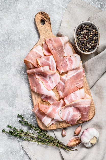 Фото Свежий свиной бекон на разделочной доске органическое сырое мясо свинины