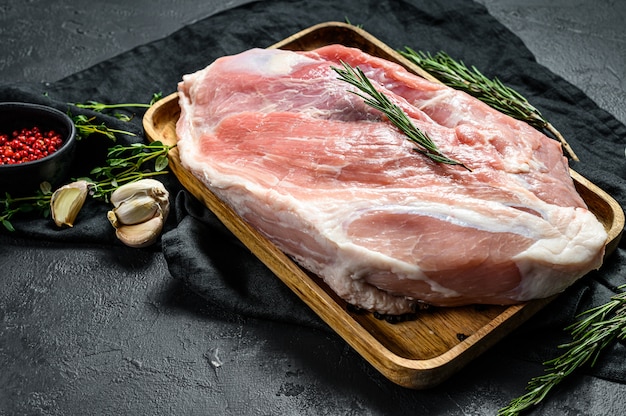 Photo fresh pork cuts. raw meat with spices.  hind leg steak. black background. top view