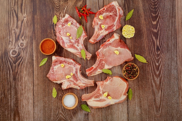 Photo fresh pork meat bone in on wooden background with spices.