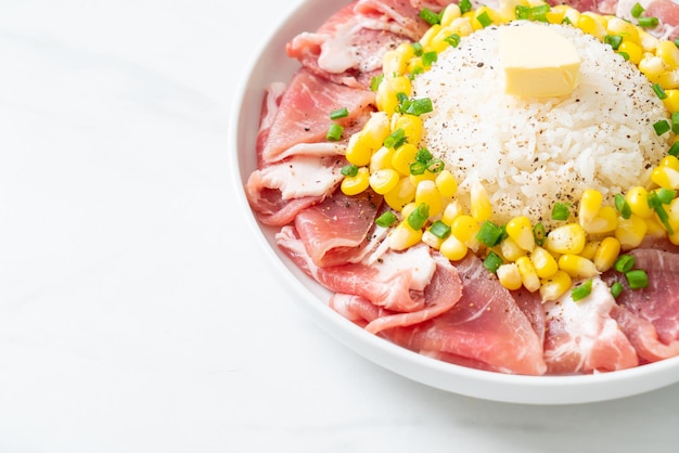 fresh pork raw sliced with rice and corn on white plate and ready to cook