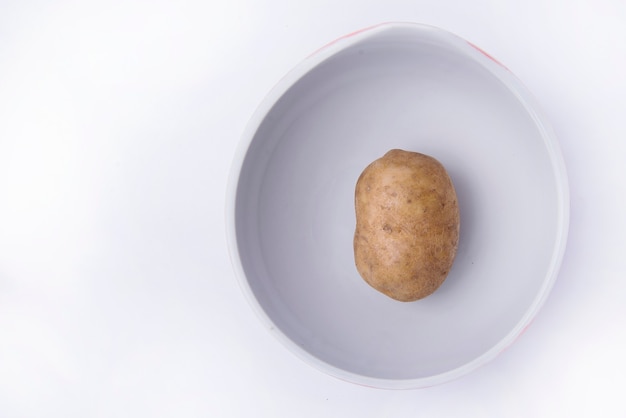 Fresh potato on the bowl isolated over white background