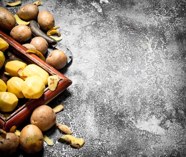 Fresh potatoes in an old tray. On rustic table