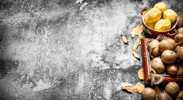 Fresh potatoes in an old tray. On rustic table