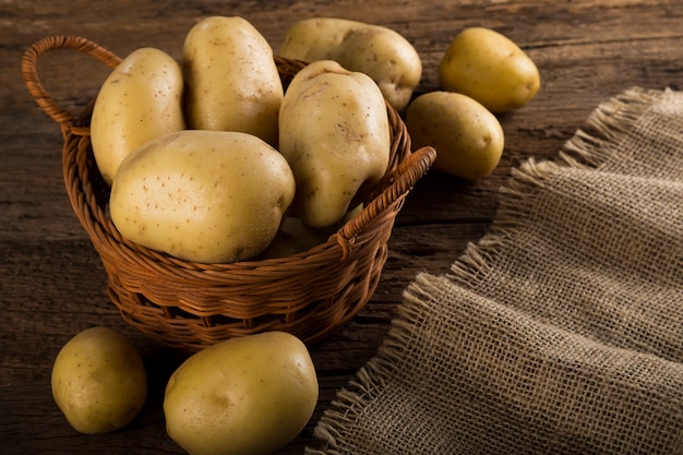 Fresh potatoes on the wooden table Raw potatoes