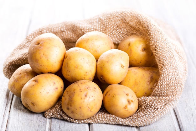 Fresh potatoes on wooden table