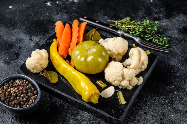 Conserve fresche di verdure, deliziosi sottaceti fatti in casa su una tavola di marmo.