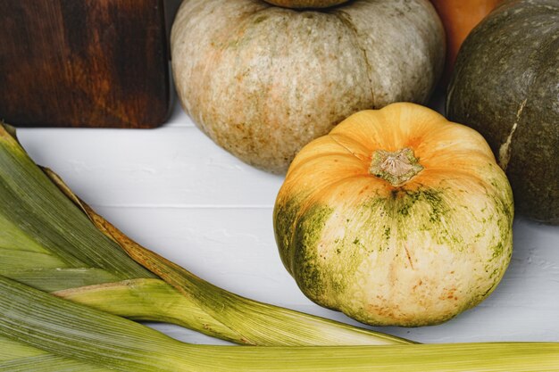 Foto zucca e porro freschi sulla tavola bianca