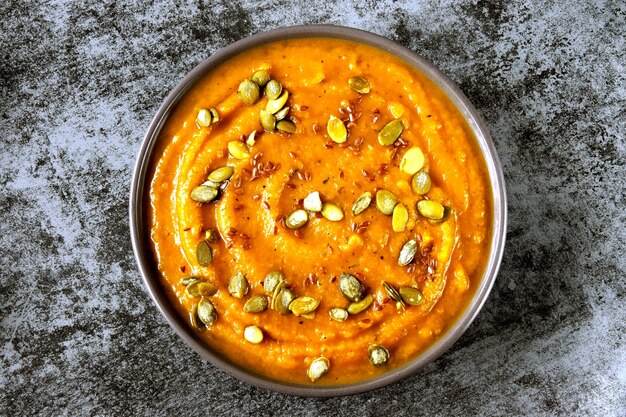 Fresh pumpkin soup in a bowl. Autumn homemade pumpkin soup. Vegan bowl with healthy food.