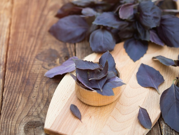 Fresh purple basil leaves in wooden bowl