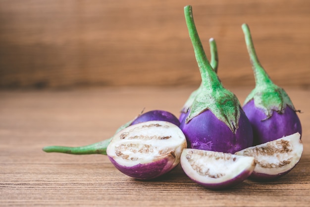 Fresh Purple eggplants on wooden table. Free space for text