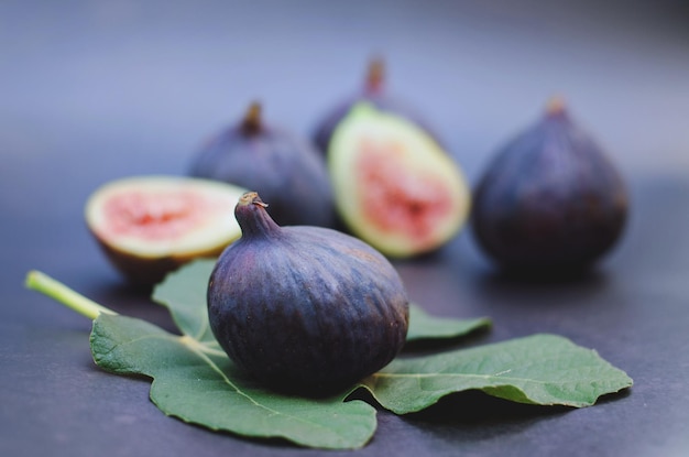 Fresh purple figs, herbs lie on the table on dark background close up. Top view. Flat lay. Food