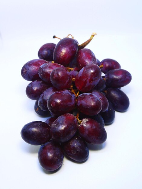 Fresh purple grapes on the white background