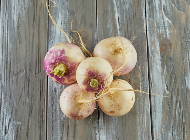 Fresh purple turnip stacked on wooden gray background