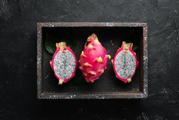Фото Свежая питахья на черном фоне драконий фрукт тропические фрукты вид сверху свободное место для текста