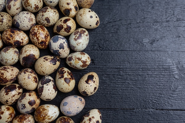 Fresh quail eggs on the dark wooden surface.