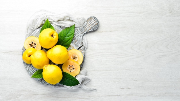 Fresh quince fruits on a wooden board Top view Free space for text