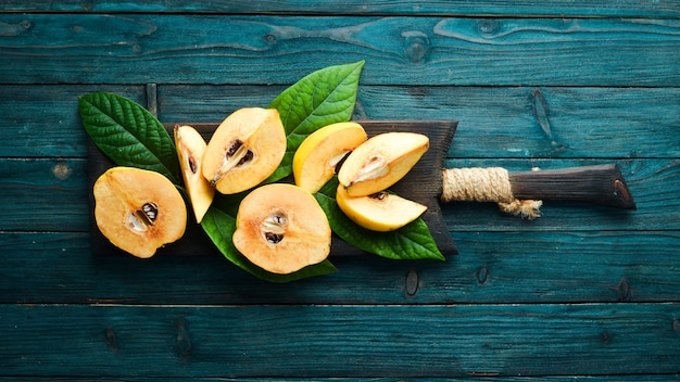 Fresh quince fruits on a wooden board Top view Free space for text