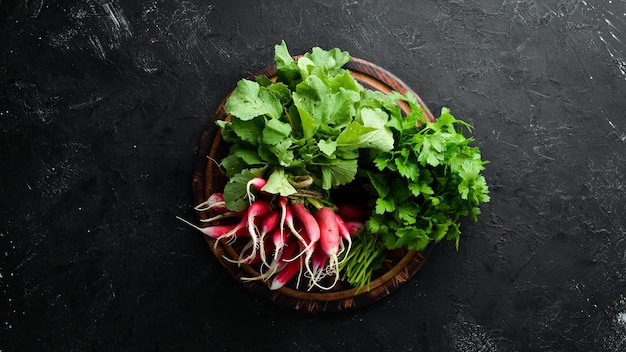 Fresh radish on a black stone background Red radish Top view