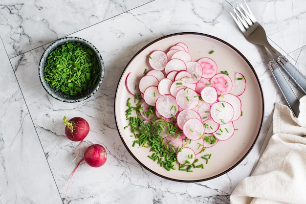 Photo fresh radish and green onion salad on a plate on the table home cooking top view