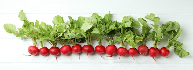 Fresh radish on white wooden surface, space for text